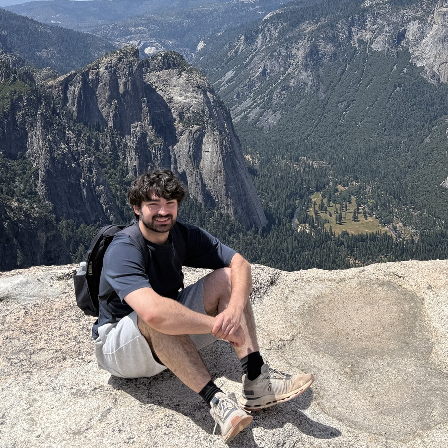 Vachagan seated on a rock above a mountain valley